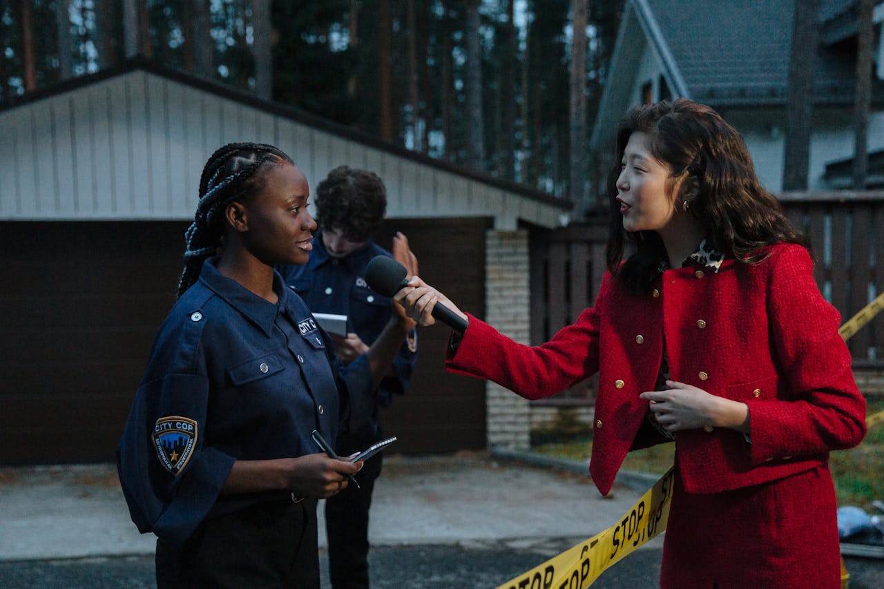 services-03 A journalist interviewing a policewoman at a crime scene during twilight.
